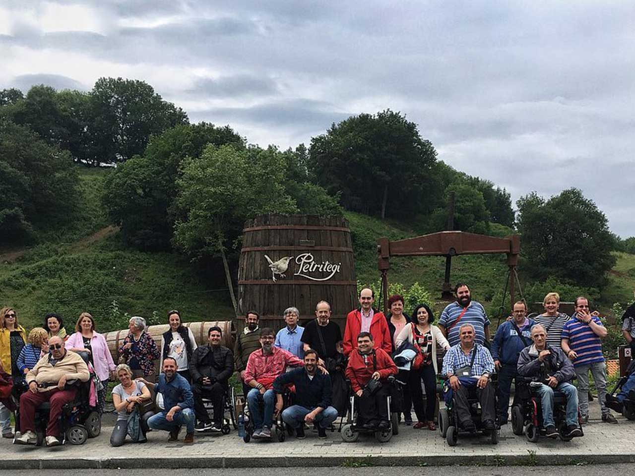 Grupo de personas en la sidrería Petritegi, algunas de ellas usuarias de silla de ruedas.