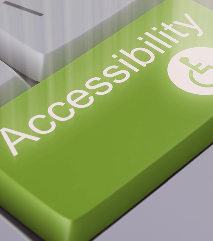 Tecla de ordenador en color verde con la palabra “accessibility” y el pictograma de movilidad reducida.